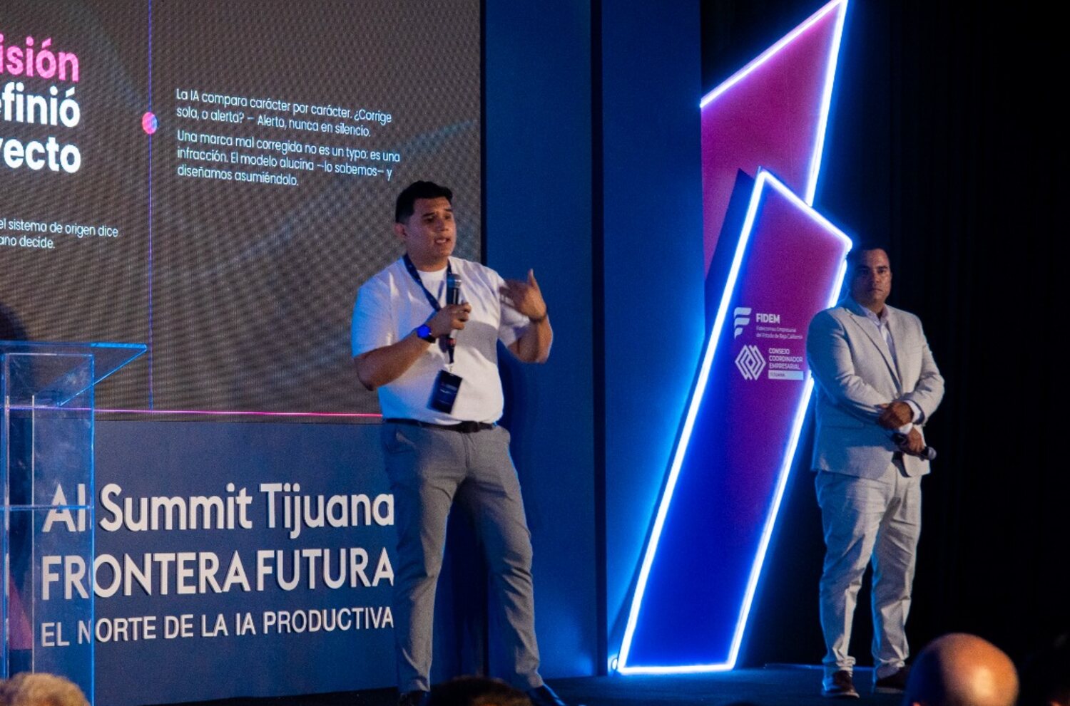 Andrés Wong y Josué Madera en el escenario con el slide La decisión que definió el proyecto